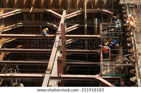 HO CHI MINH, VIETNAM- AUG 9 : Construction worker working on bridge site at Sai Gon river, this project belong metro plan from Ben Thanh, man welding steel bar on framework, Viet Nam,  August 9, 2014