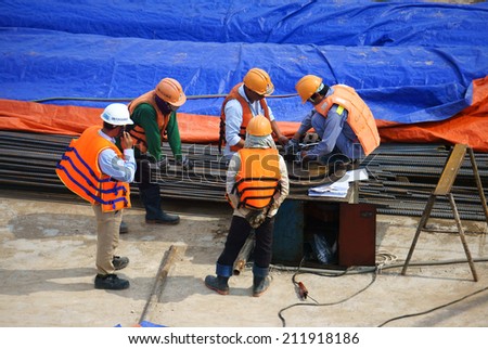HO CHI MINH, VIETNAM- AUG 9 : Group of Asia construction worker working on bridge site at Sai Gon river, project belong metro plan from Ben Thanh, crowd of man in teamwork, Viet Nam,  August 9, 2014