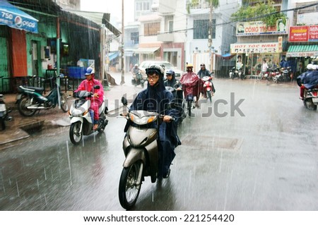HO CHI MINH CITY, VIET NAM- SEPT 30: Group of Vietnamese people drive motorbike in heavy rain day, person wear helmet, raincoat move in raining and wind, Vietnam, Seot 30, 2014