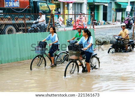 HO CHI MINH CITY, VIET NAM- OCT2: Group of Vietnamese people ride motorbike, bike moving on flooded street after rain, cause construction work, vehicle have to trafiic in difficult, Vietnam, Oct2,2014