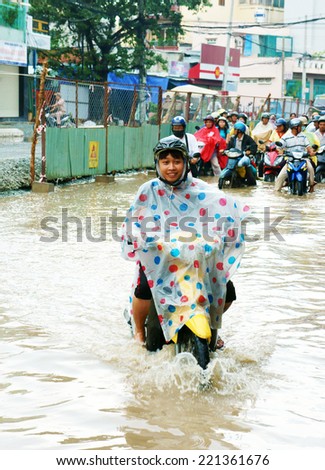 HO CHI MINH CITY, VIET NAM- OCT2: Group of Vietnamese people ride motorbike, bike moving on flooded street after rain, cause construction work, vehicle have to traffic in difficult, Vietnam, Oct2,2014
