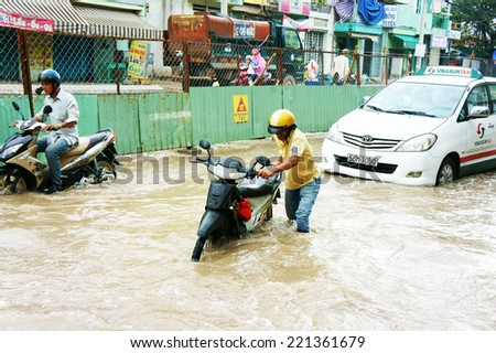HO CHI MINH CITY, VIET NAM- OCT2: Group of Vietnamese people ride motorbike, bike moving on flooded street after rain, cause construction work, vehicle have to trafiic in difficult, Vietnam, Oct2,2014