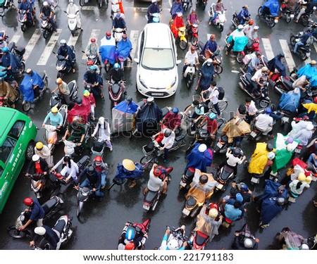 HO CHI MINH CITY, VIET NAM- OCT 6: Impression, colorful scene of Asia city in rush hour after rain evening, crowd of Vietnamese people wear raincoat, on motorbike, crowded on street, Vietnam, Oct 6, 2014