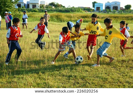 BINH THUAN, VIETNAM: Group of Unidentified Asian kid playing football in team, Vietnamese little boy run on grass, outdoor activity of children physical education at countryside, Viet Nam, Oct26, 2014
