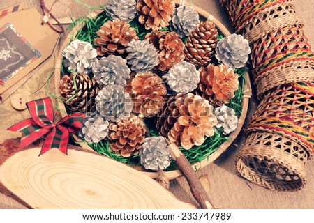 Impression arrangement with natural material, Christmas pine cone in art basket, wooden pen to send message onto oval board,  Xmas card make vintage style for decoration