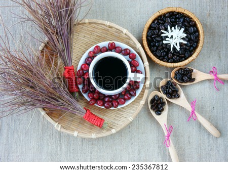 Harmony creative for decor from coffee bean, cup of black cafe,  ripe berries, basket of roasted cafe bean, white flower,  wooden spoon, set up on sackcloth background make amazing conceptual