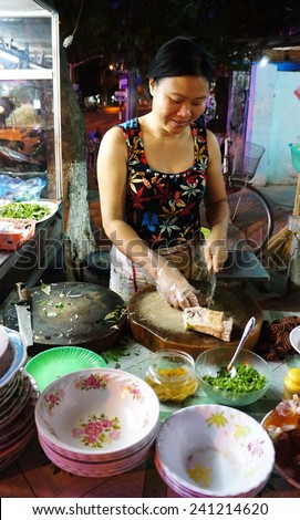 HO CHI MINH CITY, VIET NAM- DEC 29:  Vietnamese food store on pavement at Can Gio night, Asian woman sell hot duck porridge, a nutrition, delicious street food, Vietnam, Dec 29, 2014