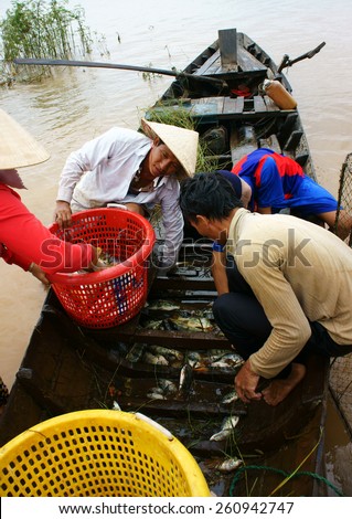 DONG NAI- VIET NAM- AUST 31: Group of Asian fisherman fishing on Tri An lake, a branch of Dong Nai river, crowd of people collect river fish on row boat, Vietnam, Aust 31, 2014
