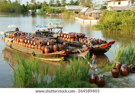 BEN TRE, VIET NAM- MAR 24: Transportation handicraft product at Mekong Delta river, beauty, colorful scene of Vietnamese countryside at evening, Vietnam, Mar 24, 2015