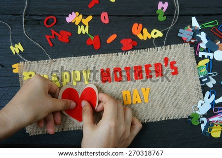 Happy mothers day with i love mom message,  idea from colorful letter on wooden background, woman hand cutting character to make gift for mother on happy day, show feeling with mother, love family