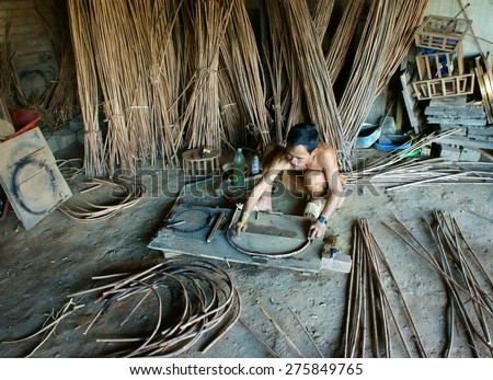 LAM DONG, VIET NAM- MAY 1: Vietnamese worker working inside of home at trade village  to make traditional product, rattan basket from nature material, clever hand, Vietnam, May1, 2015