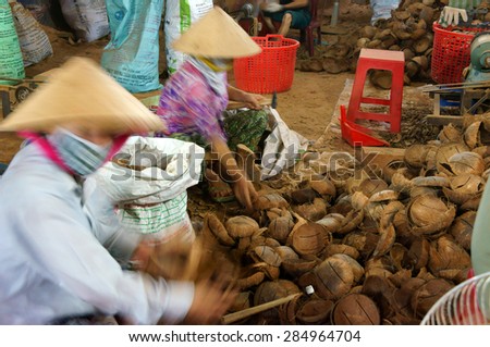 BEN TRE, VIET NAM- JUNE 2: Asian worker working at wood workshop, Vietnamese people make product from coconut tree trunk, tradition craft,  in polluted enviroment, Mekong Delta, Vietnam, June 2, 2015