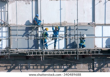 HO CHI MINH CITY, VIET NAM- NOV17: Group of Asian construction worker working on scraffold at apartment building site, Vietnamese man climbing, danger, unsafe for builder, Saigon, Vietnam, Nov17, 2015