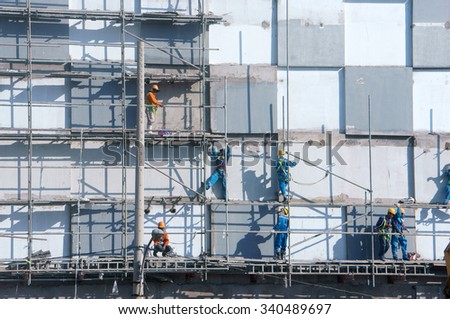 HO CHI MINH CITY, VIET NAM- NOV17: Group of Asian construction worker working on scraffold at apartment building site, Vietnamese man climbing, danger, unsafe for builder, Saigon, Vietnam, Nov17, 2015