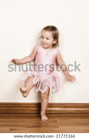 Little girl with short hair wearing a pink ballet outfit - stock photo
