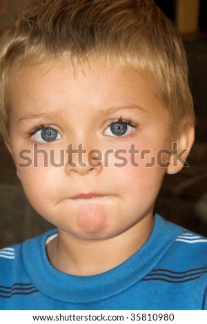 Young boy with beautiful blue eyes, serious expression