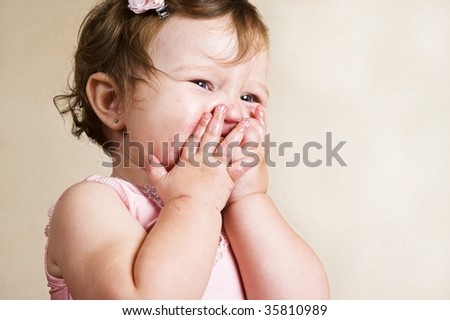 Baby girl with sticky hands and face, sad cause someone took her sweet away