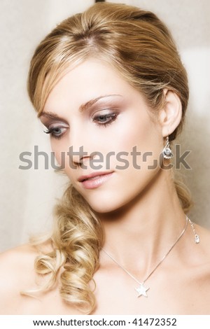 Beautiful Blond bride with blue eyes wearing diamond jewelery