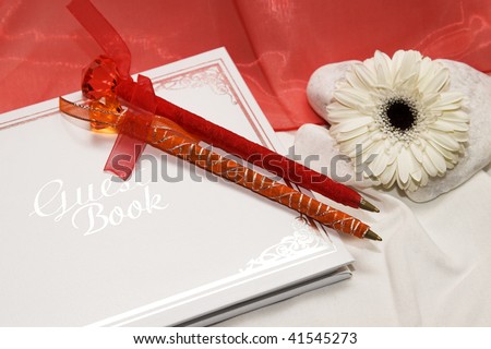 White and silver guest book with pens at a wedding