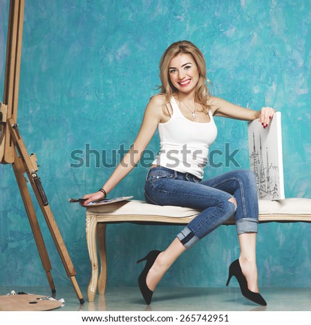 Beautiful smiling woman with brush, palette and painting