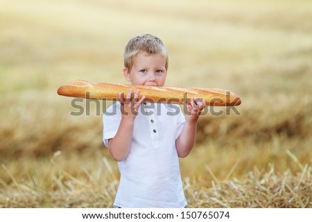 Child with long loaf in the wheat field