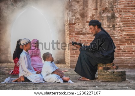 Muslim teacher teach koran to his children in old mosque