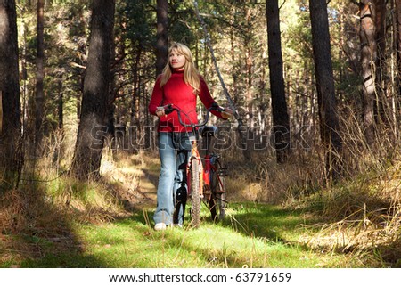 woman goes on forest with bicycle