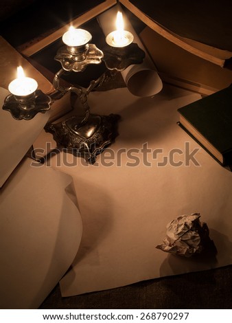 composition of old paper, candle and books