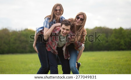 Fun outdoors. Young man and two young woman making fun