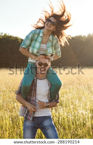 The girl is sitting on the neck of the guy.