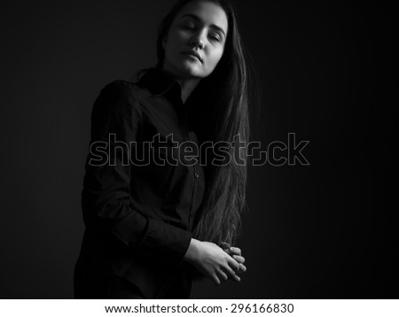 Thoughtful young woman in black with closed eyes. black and white