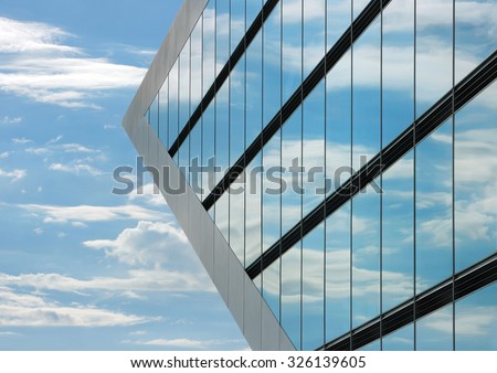 Part of the Dockland office building in Hamburg. The windows of the building reflecting the sky with clouds and creating a surreal view.