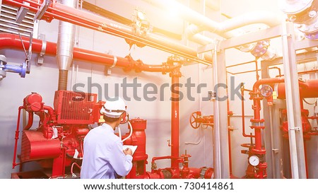 Engineer check red generator pump for water sprinkler piping and fire alarm control system.