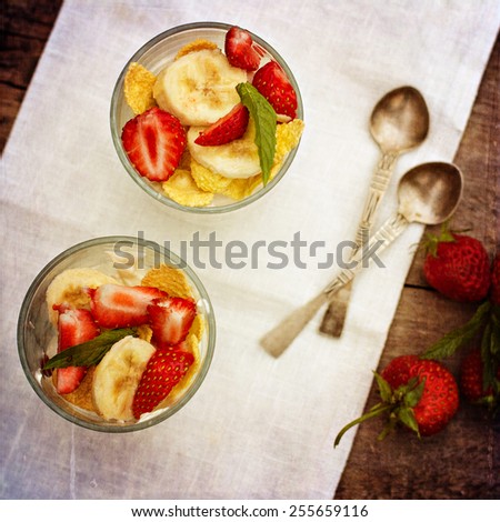 Dessert with strawberries.Cheese, strawberry, banana, cornflakes on the table. Breakfast. Toned photo.
