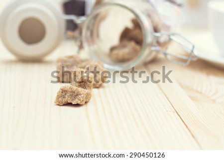 Brown sugar, a few pieces.  Pieces of brown sugar spilling on the table