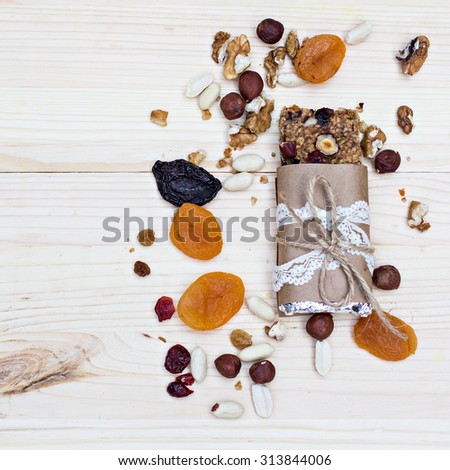 Homemade rustic granola bars with dried fruits and handmade packaged  on wooden background