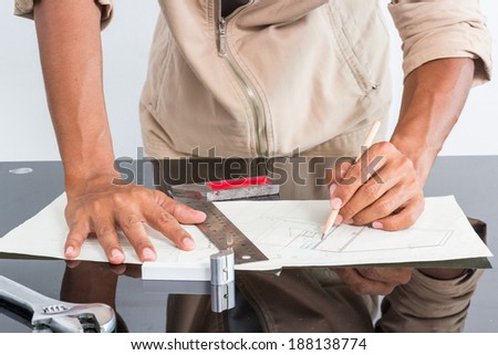 engineer is working on table with drawing and tools