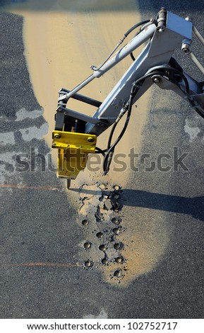 Jackhammer - pneumatic drill breaking street asphalt, repairing damaged water supply
