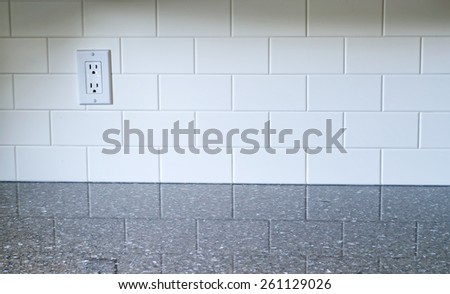 White Kitchen backsplash with a white outlet on the left side with quartz countertop