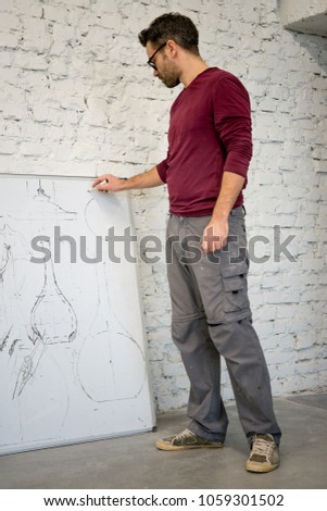 Young Designer Drawing the Sketch on the Big Whiteboard in the White Studio