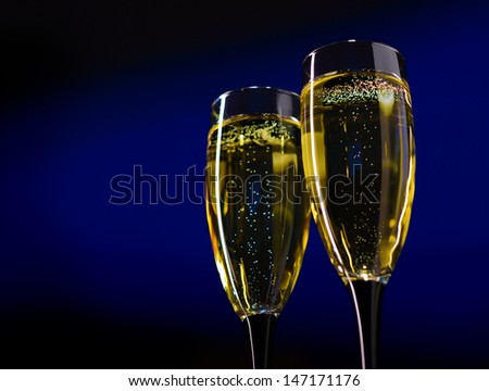 Two Glasses of Champagne Against Dark Blue Background