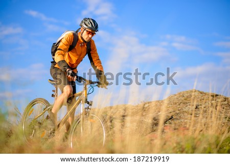 Cyclist Riding the Bike on the Beautiful Autumn Mountain Trail