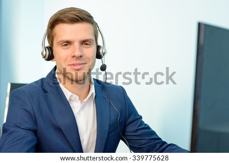 Young Customer Support Phone Operator with Headset at his Working Place in the Office.
