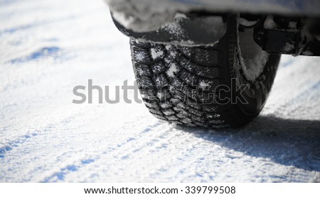 Close-up Image of Winter Car Tire on the Snowy Road. Drive Safe Concept