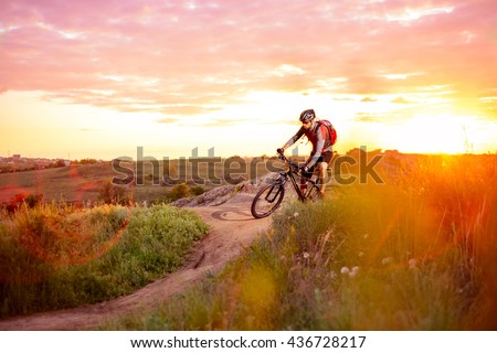 Cyclist Riding the Bike on the Mountain Rocky Trail at Sunset. Extreme Sports