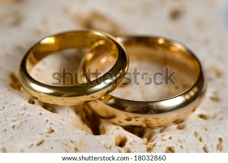 stock photo Pair of gold wedding rings on a stone