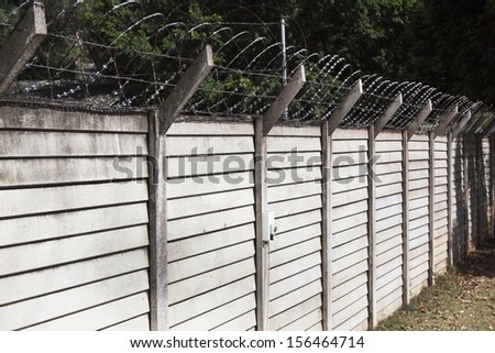 Precast concrete wall with razor sharp security wire protecting property