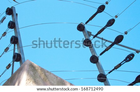Closeup of electric fence installation on boundary wall against blue sky