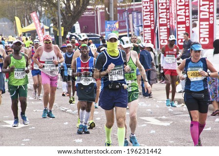 DURBAN, SOUTH AFRICA - JUNE 1, 2014: Masked runner and many other competitors  compete in the long distance Comrades Ultra Marathon between Pietermaritzburg and Durban in South Africa.