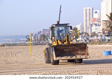 DURBAN, SOUTH AFRICA - JULY 2, 2014; Payloader works on beach on Golden Mile beachfront in Durban, South Africa